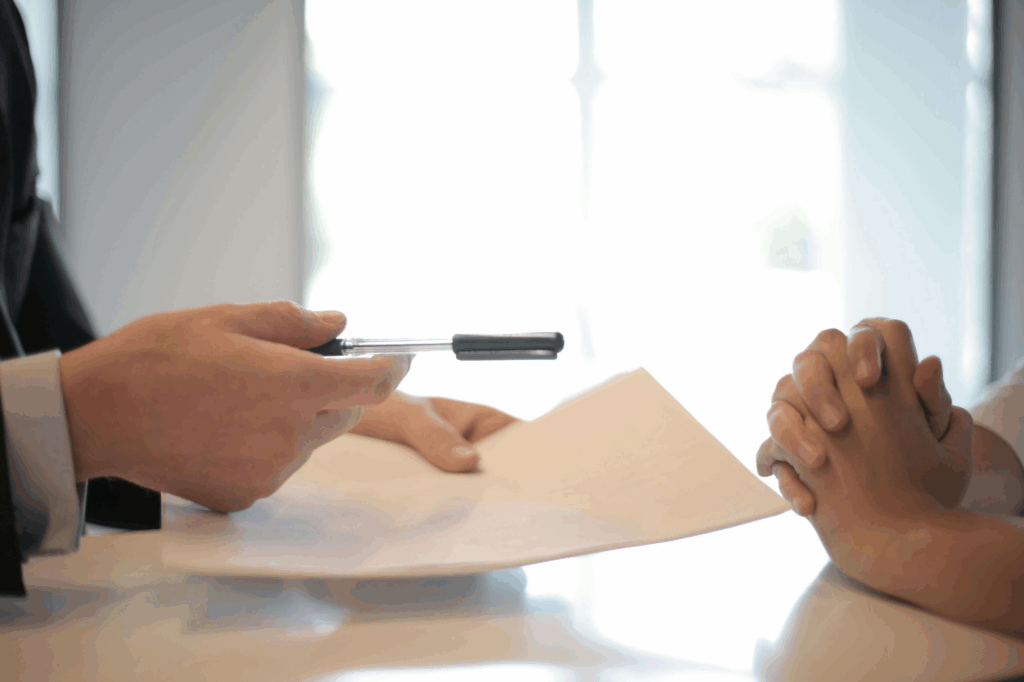 a person handing over a pen to another
