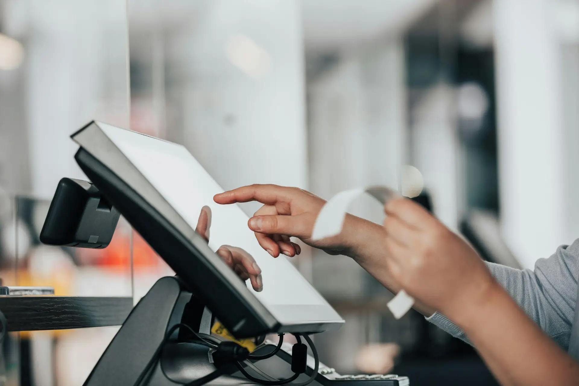 Dispensary worker holding a receipt and using a checkout system at the register