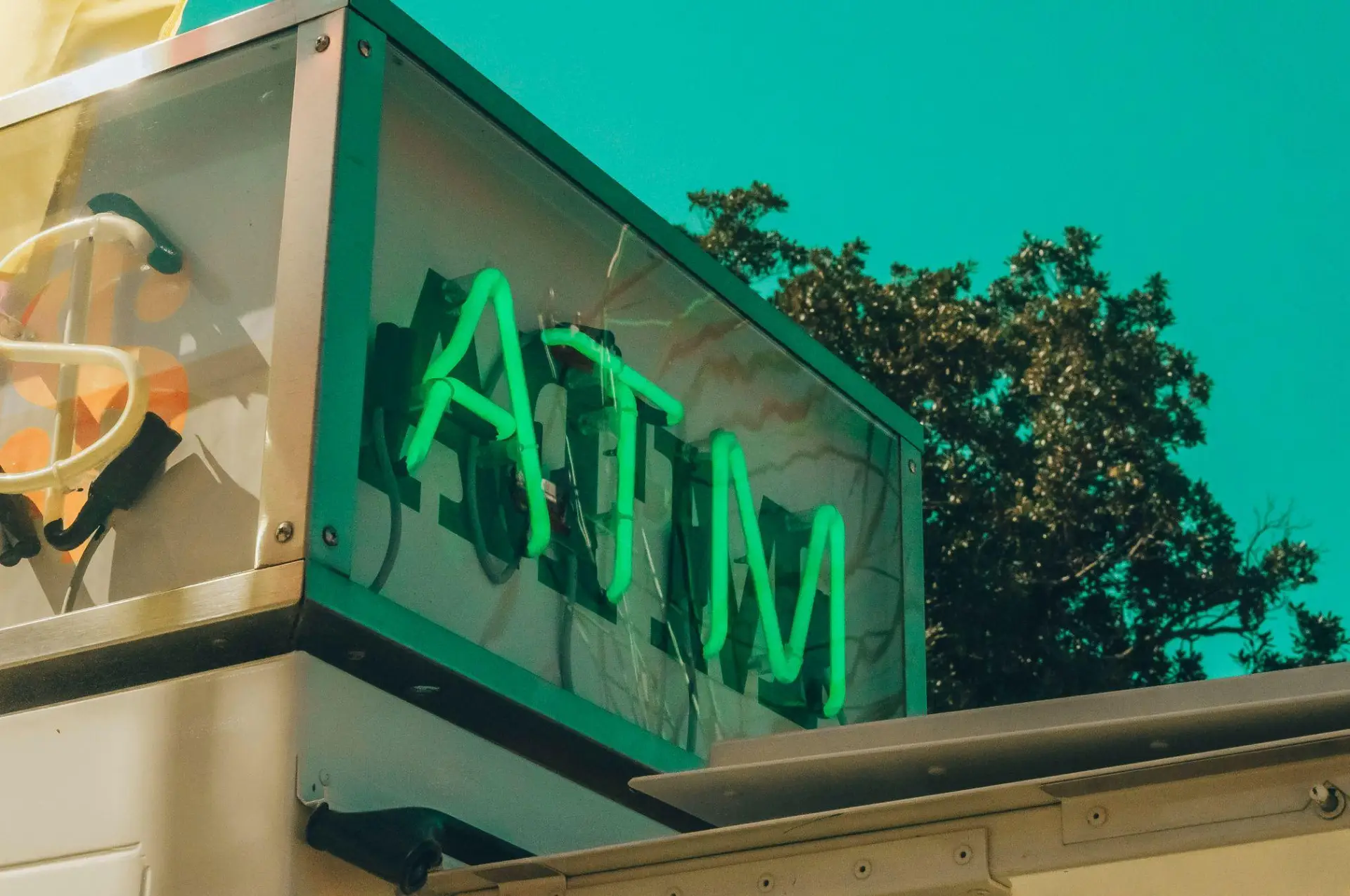 neon green ATM sign outdoors representing visible dispensary ATM signage and customer-facing fee disclosures